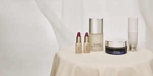 SENSAI Geschenke zum Muttertag auf einem Tisch mit goldener Tischdecke vor hellem, neutralem Hintergrund